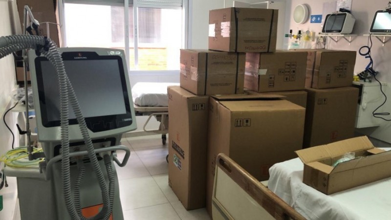 A imagem mostra equipamentos médicos (alguns embalados) dentro de um quarto de hospital.  